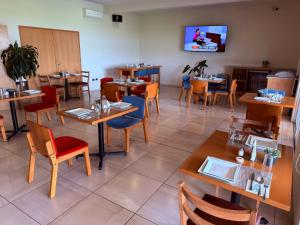 a restaurant with tables and chairs in a room at Hit Hoteles Aeropuerto Puebla in Huejotzingo