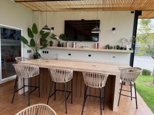 a kitchen with a bar with four chairs around it at Hit Hoteles Aeropuerto Puebla in Huejotzingo