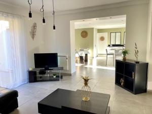 Una sala de estar con un sofá y un televisor. en Villa du Vallon, en Allemagne-en-Provence