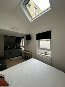 a bedroom with a white bed and a skylight at Ixelles - Cozy studio in middle of European District in Brussels