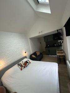 a bedroom with a white bed and a couch at Ixelles - Cozy studio in middle of European District in Brussels