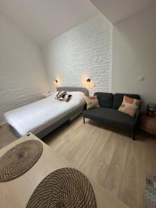 a bedroom with a large bed and a couch at Ixelles - Cozy studio in middle of European District in Brussels