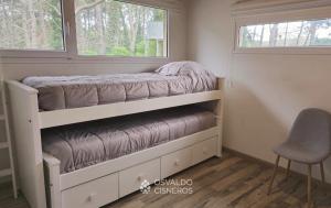 ein Etagenbett in einem winzigen Haus mit Fenster in der Unterkunft Los Patitos in Mar de las Pampas