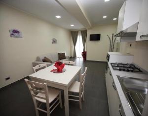 a kitchen and living room with a white table and chairs at B&B Alba Chiara in Taurianova