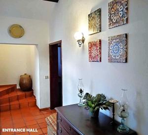 a room with a dresser and paintings on the wall at Prédio do Castelo in Caloura