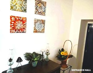 a room with a table with flowers and pictures on the wall at Prédio do Castelo in Caloura
