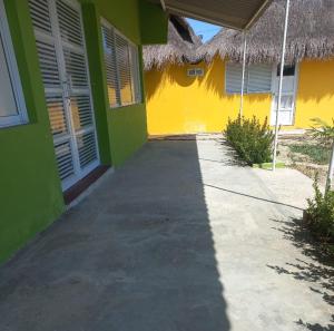 a yellow and green building with a sidewalk next to it at Dulce Barú in Ararca