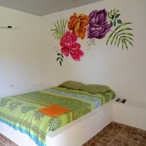a bedroom with a bed with flowers on the wall at Dulce Barú in Ararca +26 photos