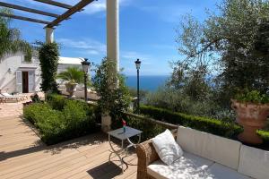 a patio with a couch and a table and the ocean at Villa Antonella Amalfi Coast in Praiano