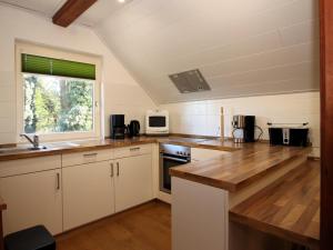 a kitchen with white cabinets and a sink and a window at Ferienwohnung im Reetdachhaus, Burhave in Burhave +12 photos