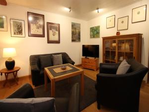 a living room with couches and a tv and a table at Ferienwohnung im Reetdachhaus, Burhave in Burhave