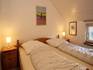 two twin beds in a bedroom with two lamps at Ferienwohnung im Reetdachhaus, Burhave in Burhave