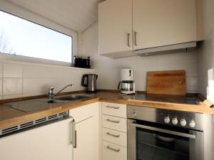 a kitchen with a sink and a stove at Ferienwohnung im Reetdachhaus, Burhave in Burhave +9 photos