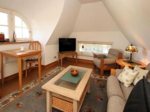 a living room with a couch and a tv at Ferienwohnung im Reetdachhaus, Burhave in Burhave