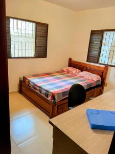 sypialnia z łóżkiem i biurkiem oraz dwoma oknami w obiekcie Casa de campo em condominio w mieście Esmeraldas +49 zdjęć