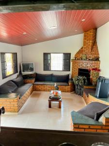 salon z kominkiem z cegły i kanapami w obiekcie Casa de campo em condominio w mieście Esmeraldas