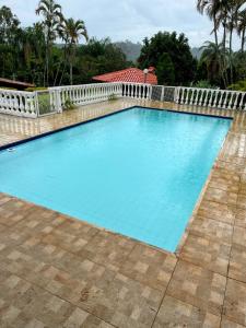duży niebieski basen z białym płotem w obiekcie Casa de campo em condominio w mieście Esmeraldas
