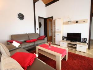 a living room with a couch and a table at Freistehender Ferienbungalow im Fachwerkstil in Burhave