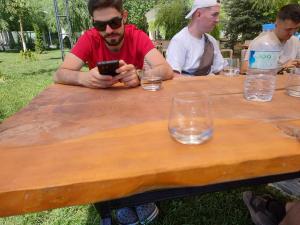 Ein Mann, der an einem Tisch sitzt und sein Handy ansieht. in der Unterkunft Studio Sport Central in Timişoara