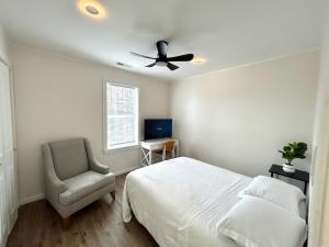 a bedroom with a bed and a ceiling fan and a chair at 2 Bedroom Apartment in SONO! in Norwalk