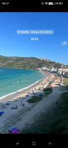a view of a beach with people and the ocean at Pousada Kundalini Arraial in Arraial do Cabo