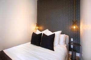 a bedroom with a bed with black and white pillows at Studio #5 - Self Check-In - Plateau - St-Denis in Montreal