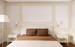 a bedroom with a bed with two night stands and two tables at Garabagh Resort & Spa Naftalan in Naftalan