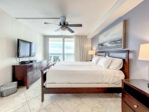 クリアウォーター・ビーチにあるOceanfront Condo Sleeps 6 Walk To Beach Poolの大きなベッドとテレビのある寝室