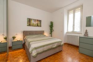 Un dormitorio con una cama grande y dos mesitas de noche. en garda garden apartment, en Roe