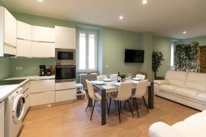 a kitchen and living room with a table and chairs at garda garden apartment in Roe