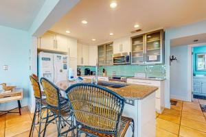 a kitchen with chairs and a island with a counter at Pensacola Beach Condos in Pensacola Beach