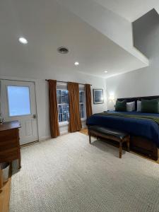 a large bedroom with a blue bed and a window at Urban Peak Escape in Lenox