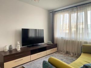 a living room with a flat screen tv on a wooden entertainment center at Apartament Corvin 1 in Hunedoara