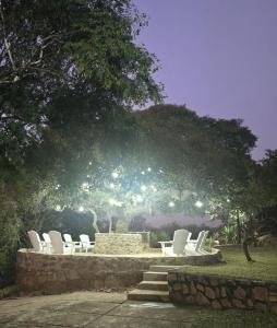 a group of white chairs sitting on a stone wall at Rocky Mountain Holiday Home in Hartbeespoort