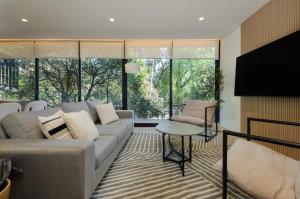 a living room with a couch and a table at Saltillo 85, Centric Condo with Balcony and Natural Light in Mexico City