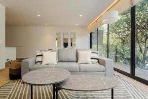 a living room with a couch and two tables at Saltillo 85, Centric Condo with Balcony and Natural Light in Mexico City