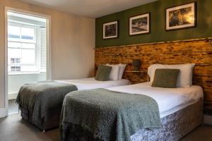 two beds in a room with green walls at Stonerock Lodge in Chepstow