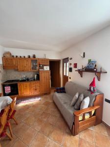 a living room with a couch and a kitchen at Casa Gaudia in Castello Tesino