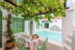 a table and chairs in front of a swimming pool at Casa Spa de la Mariola in La Puebla de los Infantes