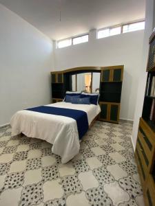 a bedroom with a large bed with blue and white sheets at Casa María Isabel in Morelia +4 photos