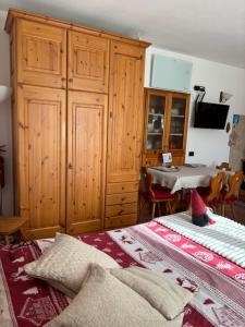 a bedroom with a bed and a cabinet and a table at Casa Gaudia in Castello Tesino