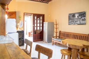 una cucina con tavolo e frigorifero di Casa de Praia em Milagres com Ar Condicionado a São Miguel dos Milagres