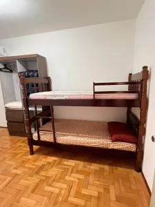 two bunk beds in a room with a wooden floor at 301- Apartamento 2 quartos próximo UFN, com garagem in Santa Maria