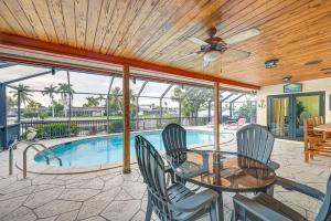 a patio with a table and chairs and a swimming pool at Marco Island Home with Private Pool and Water Views! in Marco Island