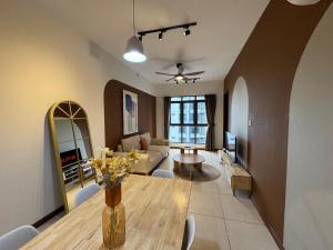 a living room with a table and a living room with a couch at Two Bedrooms K-Avenue by CC Suites in Donggongon