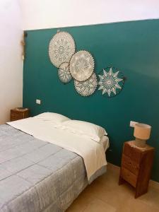 Un dormitorio con una pared verde con cuatro sombreros. en DOMUS MARIS, en Monopoli