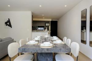 a dining room with a table and white chairs at Saltillo 85, Centric Condo with Balcony and Natural Light in Mexico City
