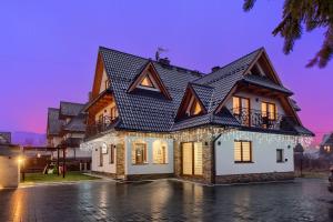 a house with christmas lights on it at DW Na Równi Białka Tatrzańska in Białka Tatrzanska