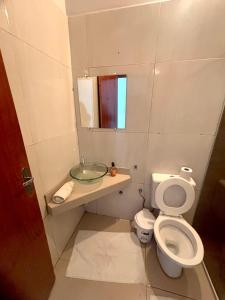 a small bathroom with a toilet and a sink at Quarto em frente aeroporto Efatá Shalom in Campo Grande +22 photos