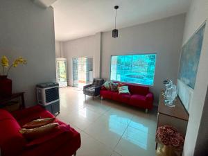 a living room with red couches and a large aquarium at Quarto em frente aeroporto Efatá Shalom in Campo Grande